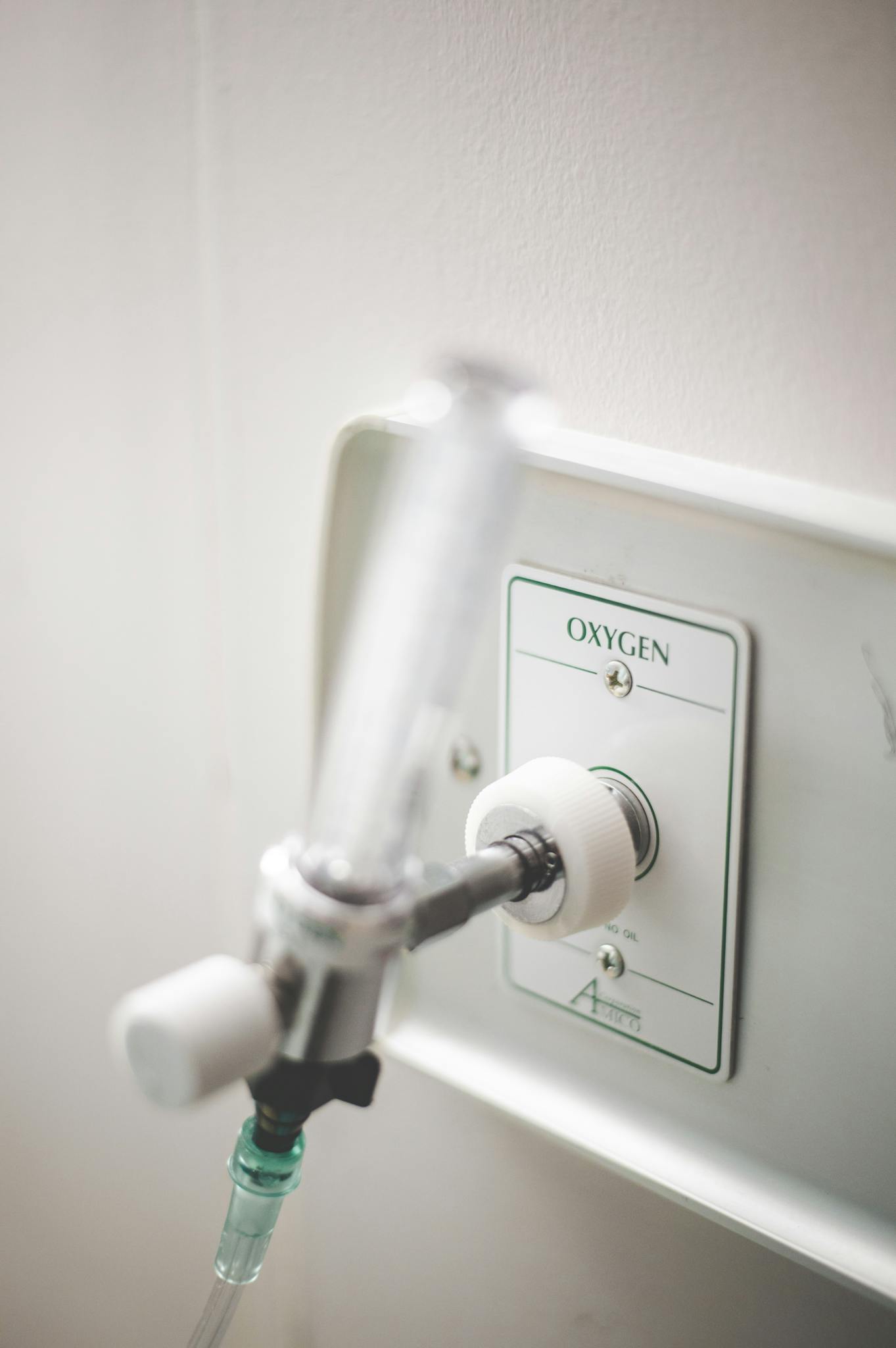 Close-up of a mounted medical oxygen supply outlet in a hospital setting.